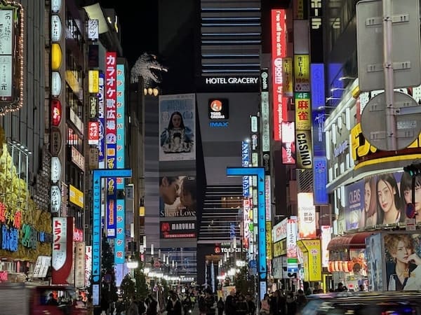 Shinjuku street with Godzilla head above Toho building during night time