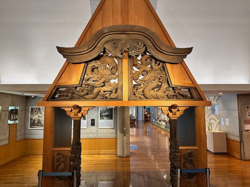 Intricately carved wooden archway on display at the museum in Oiso Joyama Park.