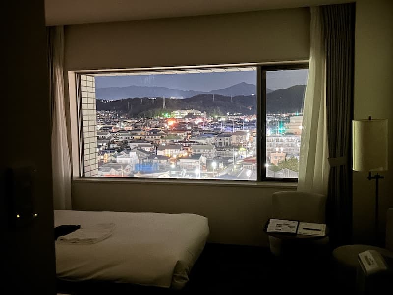 Night view from a Prince Hotel room in Oiso, showing the illuminated townscape and mountains in the background.