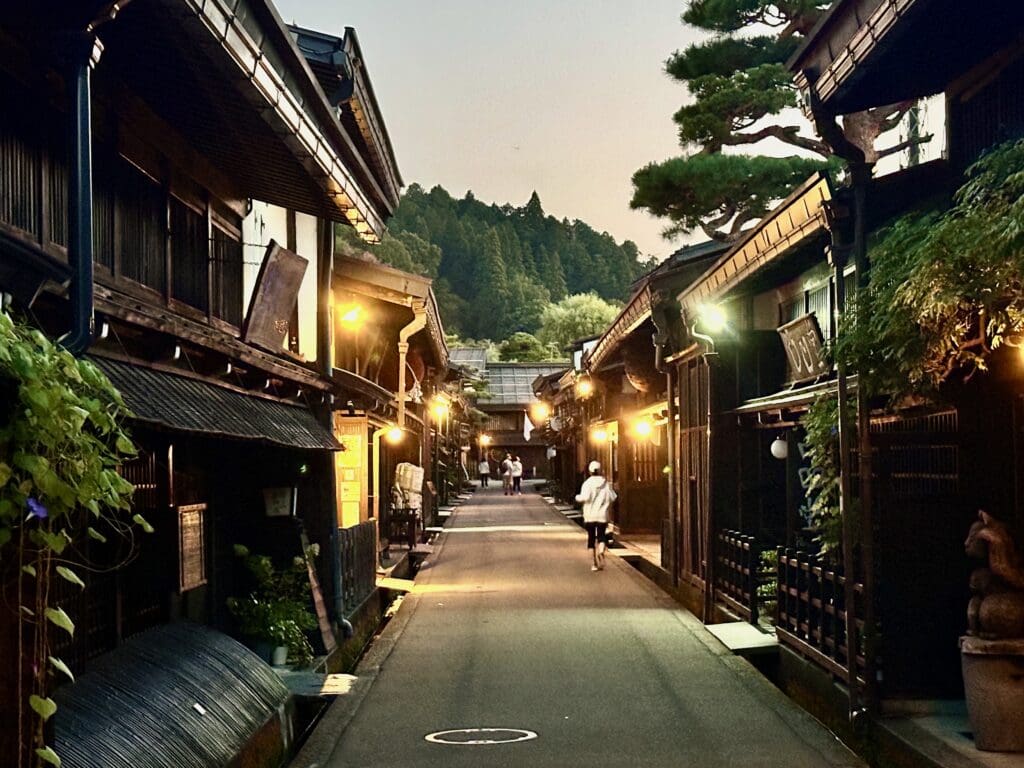 Narrow street at dusk with traditional wooden buildings in Takayama Sanmachi Kamisannomachi district