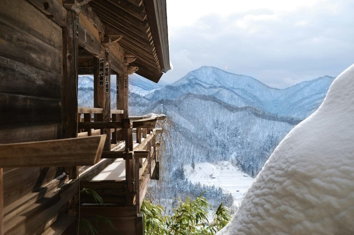 Wooden temple balcony at Yamadera overlooking snowy mountains