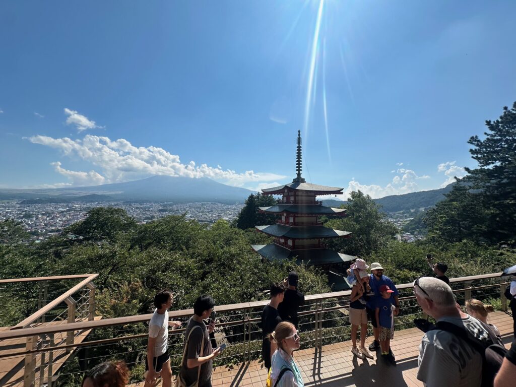 Pagoda and observation deck at Chureito Pagoda in Fujiyoshida with trees, a town view, and Mount Fuji in the distance