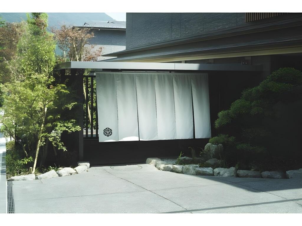 Entrance of Hakone Gora Karaku with white noren curtains and landscaped greenery