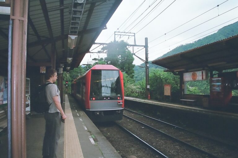 How Many Days Should You Spend in Japan on a First Trip? A train arriving at Hakone train station platform with a passenger standing nearby