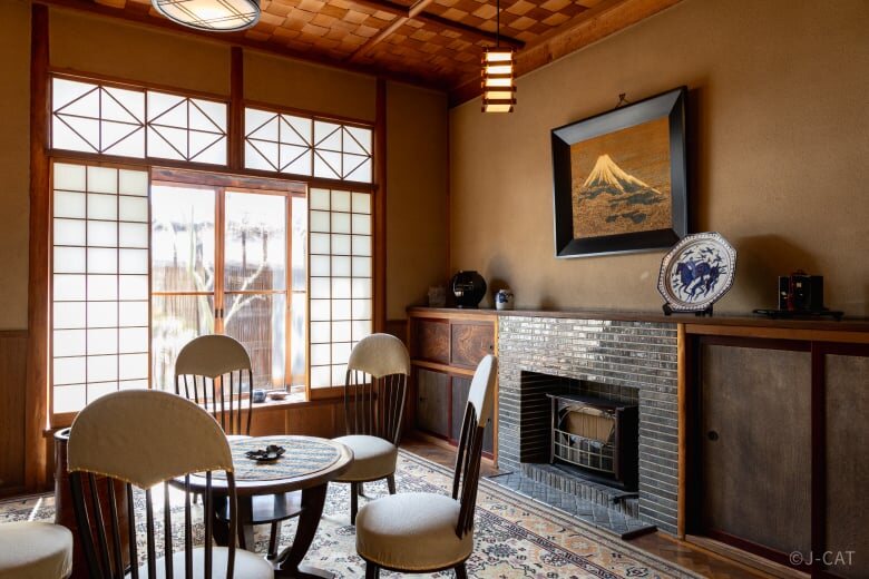 Traditional Japanese sitting room in Kyoto Nishijin with shoji screens, a fireplace, and antique furnishings