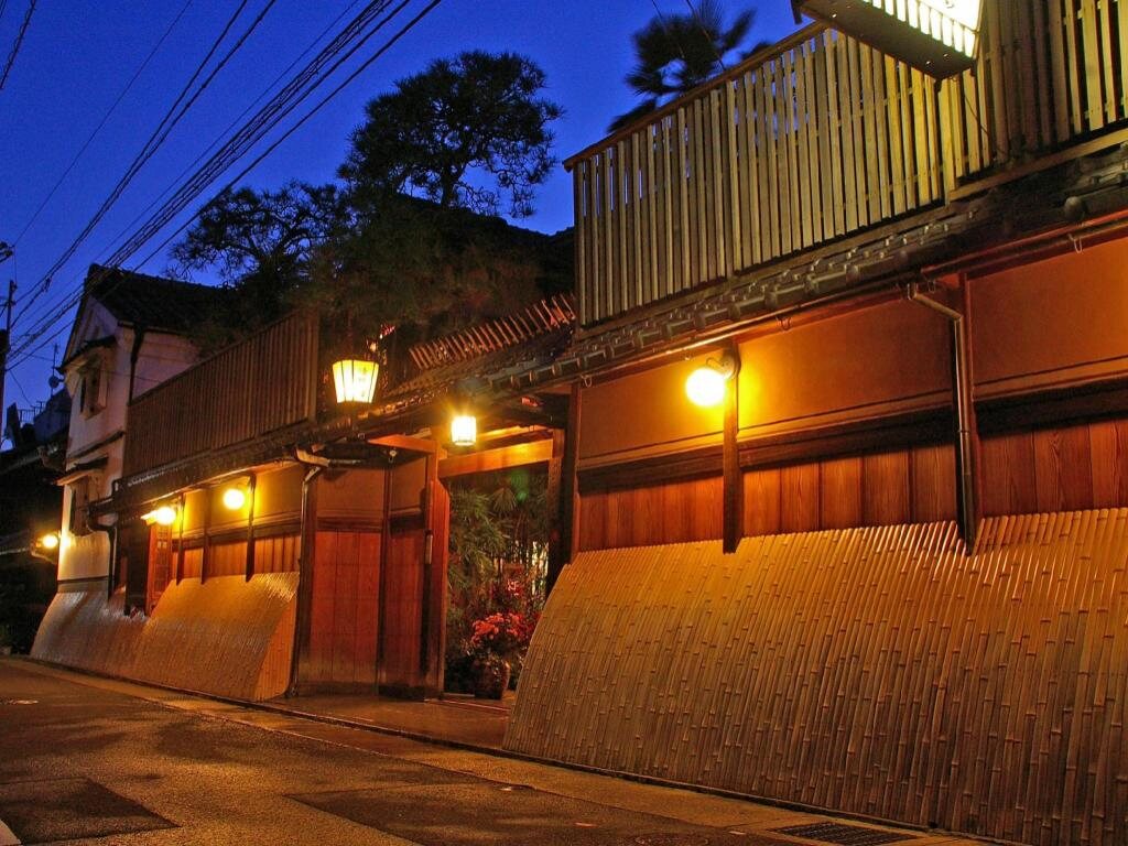 Seikoro ryokan exterior at dusk in Kyoto with warm lanterns and wooden walls
