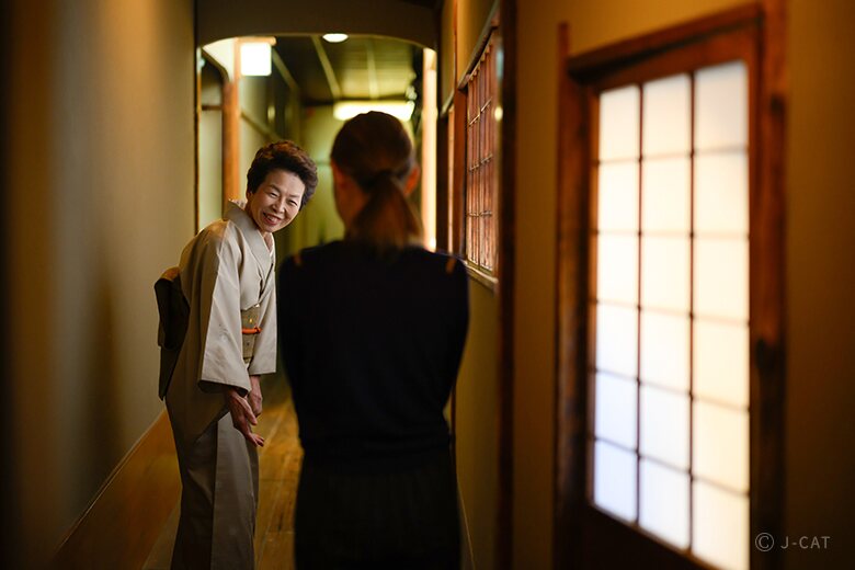 Ryokan staff greeting a guest in a Kyoto hallway
