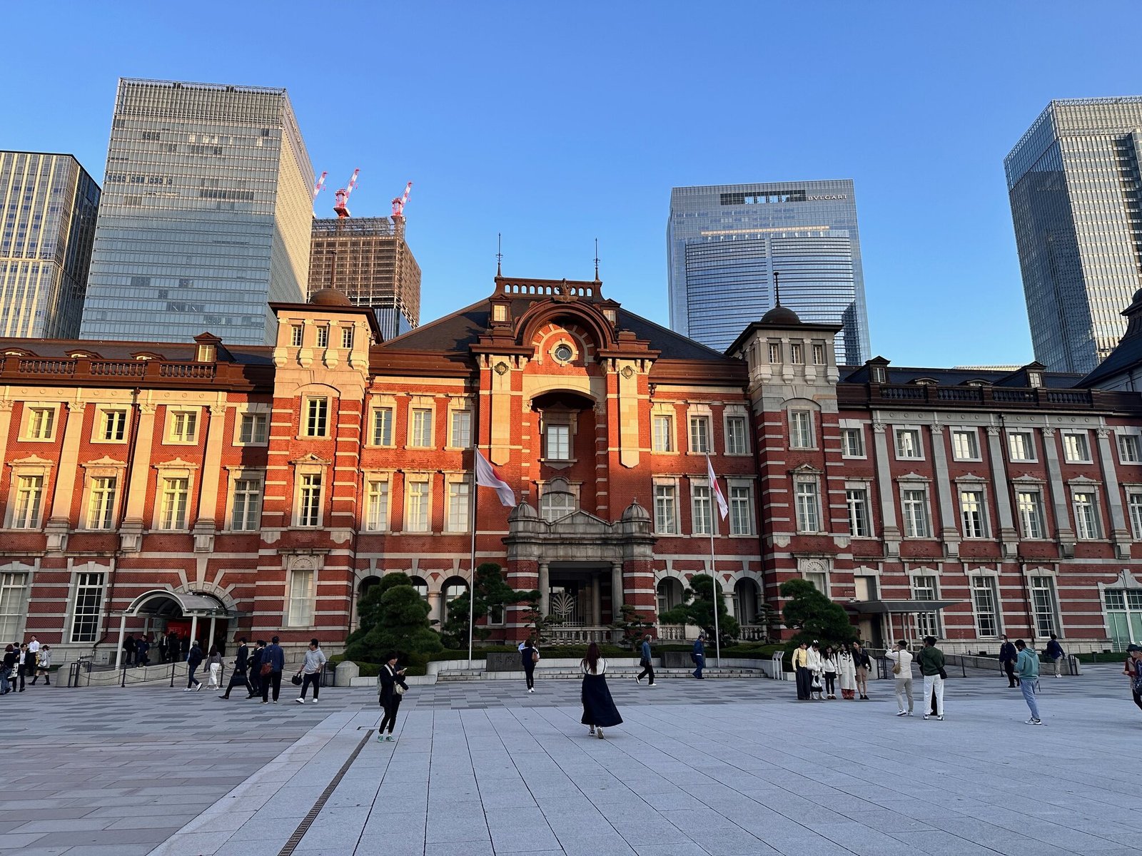 Tokyo Station Marunouchi facade with red-brick architecture and clock at the entrance, surrounded by office towers