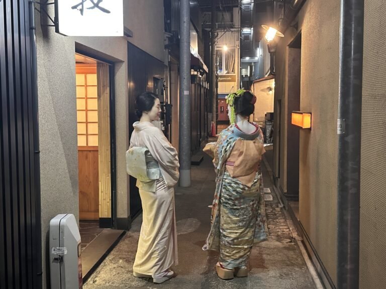 Private Geisha Dinner in Tokyo: My Experience at Ryotei Maki Two women in kimono standing in a narrow alley in Kagurazaka, Tokyo at night