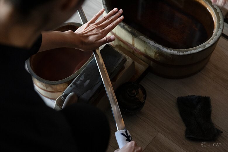Hands polishing a katana at Buneido in Setagaya, Tokyo